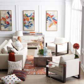 A living room with white, contemporary-style furniture, a pink marble coffee table, gray/marble chest, home decor, and modern wall art