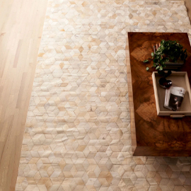 A light blue, wide floor-length mirror in a bedroom with a white, fuzzy rug, next to a framed photo and a basket with laundry in it. In the reflection is a wooden dresser with a white vase and miscellaneous items on top. On the left are French doors leading outside.