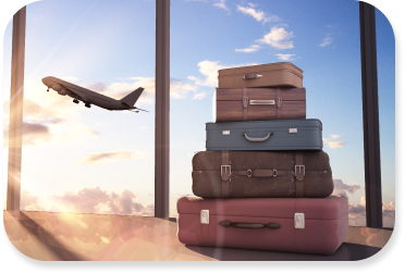A stack of five pieces of luggage sit in front of a large window with an airplane taking off outside.